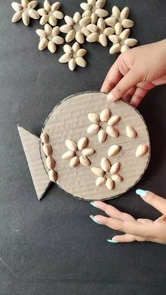 two hands reaching for almonds in front of a fish shaped paper plate with an arrow on it