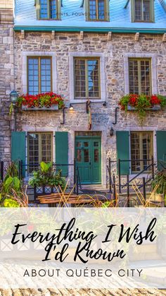 an old stone building with green shutters and flowers on the windows