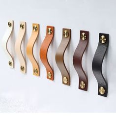 an assortment of different colored handles on a white wall