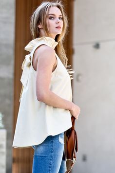 There’s no need to sacrifice style for comfort with this dreamy latte-hued blouse. Equal parts polished and playful, it features a ruffled tie neckline and flirty tie-back detail. The buttery soft fabric and flowy cut mean you’ll feel as fabulous as you look whether you’re powering through the workday or enjoying a night out. Pair it with sleek slacks or a pencil skirt for the office, then switch to distressed denim and heels for happy hour—this top is a chameleon that adapts to any occasion. Wi Chic Summer Blouse With Ruffled Collar, Chic Spring Tie Neck Tops, Chic Tie Neck Tops For Spring, Chic Spring Tops With Tie Neck, Chic Cotton Tie Neck Top, Flowy Tie Neck Top For Summer, Chic Tie Neck Top For Summer, Chic Sleeveless Blouse With Ruffle Hem, Chic Summer Top With Tie Neck