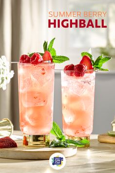 two glasses filled with ice and strawberries on top of a table