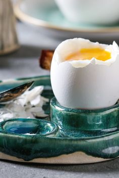 an egg is sitting on a green plate