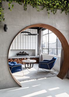 a living room filled with furniture and a fire place next to a wall covered in greenery