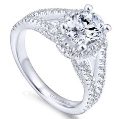 a white gold engagement ring with an oval center surrounded by round diamonds