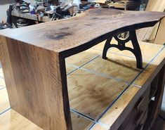 a wooden table sitting on top of a hard wood floor next to a workbench