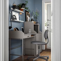 a desk with a chair and shelves on the wall behind it in a room that has blue walls