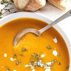 a white bowl filled with soup next to bread