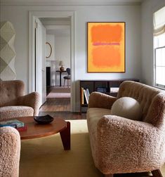 a living room filled with furniture and a painting on the wall