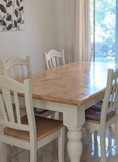 a dining room table with four chairs around it