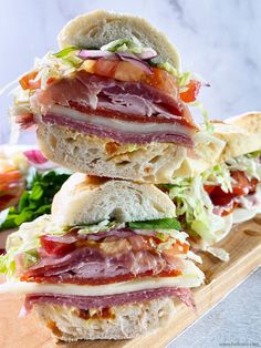 three sandwiches stacked on top of each other with lettuce, tomato and meat