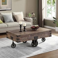 a living room with a couch, coffee table and two candles on wheels in the center