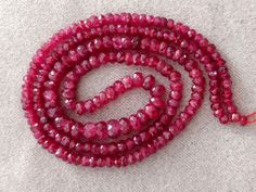 a red beaded necklace is laying on the floor