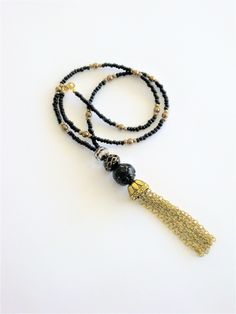 Bohemian Style black and gold beaded necklaces, handmade by Ralston Originals. These beautiful tassel necklaces come in your choice of 3 different Styles. I made the tassels with gold metal chain, and a large antique gold cap. I made the first necklace (pictures 1-3), with a large black bead with gold metal dots, and a black bead with gold stripes. The beaded chain is made with black seed beads, and gold acrylic beads. This necklace is 28 inches long, and has a lobster clasp. I made the second n Adjustable Elegant Tassel Necklace For Festival, Gold Beaded Dangle Tassel Necklace, Adjustable Beaded Chain Tassel Necklace As Gift, Gold Beaded Tassel Long Necklace, Adjustable Long Tassel Necklace With Dangling Beads, Gold Beaded Tassel Necklace, Gold Beaded Tassel Necklace Gift, Elegant Long Necklace With Beaded Chain For Festivals, Elegant Long Beaded Chain Necklace For Festivals