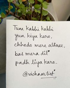 a note written on a white piece of paper next to a potted plant with green leaves