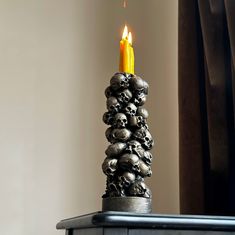 a candle that has been placed on top of a table with skulls all over it