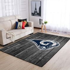 a living room with a couch, chair and rug that has the penn football team on it