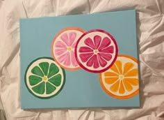 three slices of oranges and one grapefruit on a blue background painted with acrylic paint