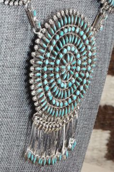 This Kingman turquoise and sterling silver necklace, earrings, bracelets, and rings set was made by Zuni silversmith Merlinda Chavez. The back of the necklace is signed D & M Chavez and Zuni.Necklace: 30"Length: 3 1/2"Width: 2 1/2"Earrings:Length: 1 3/4"Width: 1 3/4"Bracelets:Size: 5 3/4" (will fit up to a 7 1/8" wrist)Gap: 1 3/8"Length: 2 5/8"Rings:Size: 9.25 & 9.5Length: 1 3/4"Width: 1 3/4"Free shipping on all orders! We ship with USPS and always include tracking. All orders ship within a day Turquoise Round Jewelry With Sterling Silver Clasp, Turquoise Jewelry With Sterling Silver Clasp, Southwestern Style Hallmarked Round Jewelry, Southwestern Hallmarked Silver Jewelry, Bohemian Hallmarked Collectible Jewelry, Unique Turquoise Jewelry With Sterling Silver Clasp, Traditional Turquoise Jewelry Stamped 925, Southwestern Sterling Silver Jewelry With Large Pendant, Silver Southwestern Jewelry With Large Pendant