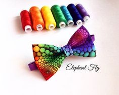 a colorful bow tie with spools of thread next to it