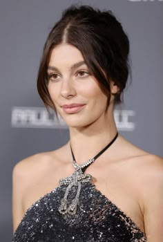 a woman wearing a black and silver dress with a choker on it's neck