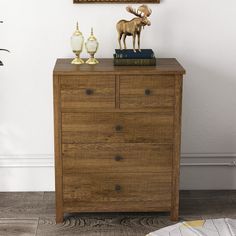 a wooden dresser topped with books and a moose figurine sitting on top of it