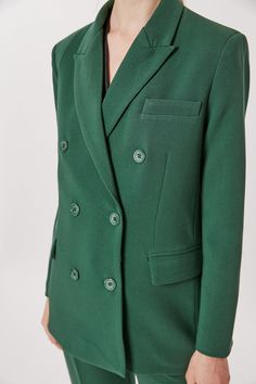 This Deluc Sophia Blazer is a stylish and sophisticated addition to your wardrobe. The double breasted blazer is crafted from a polyester-rayon blend in a bold pine green hue and features an oversized fit. The model is wearing an XS.