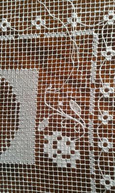 white lace with flowers on it sitting on top of a table