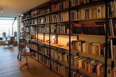 a bookshelf filled with lots of books next to a window