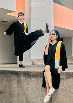 a woman sitting on top of a cement wall next to a man in a graduation gown