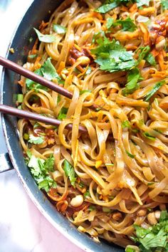 a pan filled with noodles and vegetables on top of a table