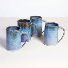 three coffee mugs sitting next to each other on a table