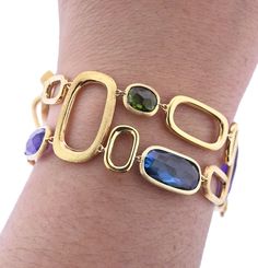 Marco Bicego Murano collection 18K yellow gold link bracelet, set with amethyst, citrine, peridot, topaz, tourmaline gemstones. DESIGNER: Marco Bicego MATERIAL: 18K Yellow Gold GEMSTONE: Spessartite garnet, Amethyst, Topaz, Peridot, Citrine CLARITY/COLOR: n/a MEASUREMENTS: Bracelet is 7" long x 1" wide MARKED/TESTED: Marco Bicego Made in Italy; Italian mark, 750 WEIGHT: 27.0 grams CONDITION: New PRODUCT ID: OG-1033 Bracelets With Gemstones, Modern Gold Multi-stone Jewelry, Modern Gold Multi-stone Gemstones, Modern Gold Bracelet With Multi-stone, Italian Gold Jewellery Design, Dimond Breslet, Italian Jewellery Design, Marco Bicego Jewelry, Italian Gold Jewelry