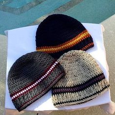 two knitted hats sitting on top of a white table next to a swimming pool