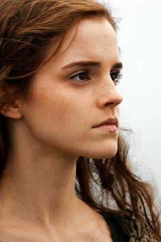 a close up of a woman with freckles on her hair and wearing a black shirt