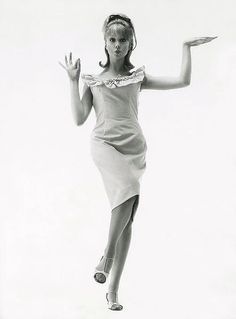 a woman is jumping in the air wearing a dress