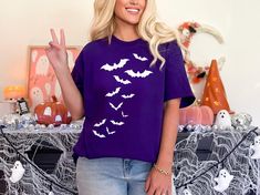 Halloween Bats Shirt, Halloween Shirt, Cute Halloween Shirt, Halloween Gift, Flying Bats Shirt, Halloween Costume Shirt, Halloween Party 🟢 HOW TO ORDER 🟢 1. Check and Review ALL Photos 📷 2. Select Your T-Shirt Style, Size and T-Shirt Color from drop down menus ✨ 3.Select Your Design Print Color from images and mention in personalization section (Optional)🎨 4. Add to cart & place order 🛒 We're constantly striving to provide excellent service. We'd love to get your feedback :) 🚚📦 SHIPPING & Purple Short Sleeve T-shirt For Halloween, Halloween Tie-dye Casual T-shirt, Multicolor Cotton T-shirt For Halloween, Halloween Fan Merchandise Short Sleeve T-shirt, Bat Shirt, Flying Bats, Costume Shirts, T Shirt Style, Halloween Novelty Cotton T-shirt