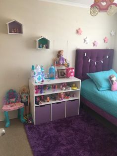 a purple and blue bedroom with toys on the shelf next to the bed in it