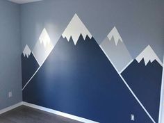 an empty room with mountains painted on the wall and carpeted flooring in front of it