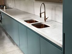 a kitchen counter with two sinks and a faucet in the middle is shown