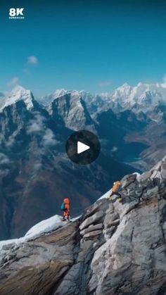 two people standing on top of a mountain