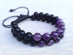 "Amethyst and Onyx Bracelet: Crafted with genuine amethyst and onyx gemstone beads, this natural healing crystal jewelry is perfect for men and women. All of the bracelets are personally handmade by me. I carefully select and use genuine natural stones and strong cords to create durable and beautiful pieces. Each piece is made to order and can be customized according to your preferences! Product Details - Handcrafted bracelet featuring 8mm amethyst and onyx beads. - Secured with a strong 1mm Black Cord. - Finished with 6mm Onyx beads as a stopper. * Amethyst: Calming and spiritual clarity. * Onyx: Protection, self-confidence, and inner strength. Size - Adjustable options available for both Men and Women. - For Women: Fits wrists from 6\" to 7.5\" [15.2 cm - 19.1 cm] - For Men: Fits wrists Mens Onyx Bracelet, Black Onyx Bracelet, Healing Crystal Jewelry, Luck Charm, Handcrafted Bracelets, Bracelet Men, Onyx Bracelet, Handmade Macrame, Onyx Gemstone