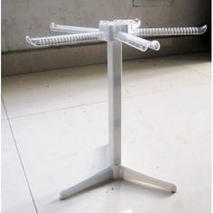 a white metal stand with three glass tubes on it's top and two legs