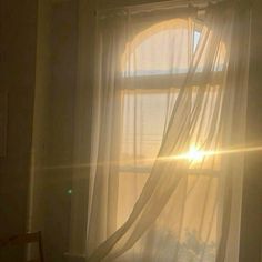 the sun shines through curtains in front of a window with sheer drapes on it