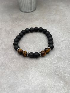 "Elevate your style with our Lava Stone & Tiger Eye Bracelet, featuring luxurious sterling silver spacers. Perfect blend of natural beauty and chic design." Crafted with care and precision, this bracelet features a durable stretch design, ensuring a comfortable fit for all wrist sizes. The 8mm beads are sized for both comfort and impact, making the bracelet substantial yet unobtrusive. This thoughtful design allows for easy wearing and removal, ideal for those who appreciate both style and conve 8mm Beads, Tiger Eye Bracelet, Eye Bracelet, Black And Yellow, Timeless Accessories, Lava Stone, Chic Design, Tiger Eye, Black N Yellow