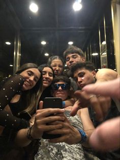 a group of people taking a selfie in front of a mirror