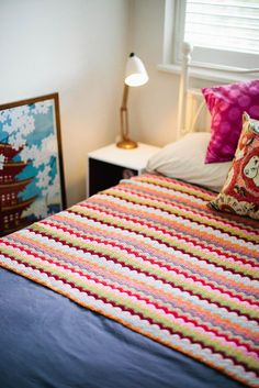 a bed with a quilt and pillows on top of it