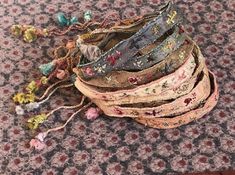 a pile of different colored bracelets sitting on top of a rug