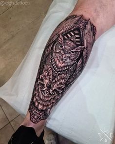 a man's arm with an owl and flowers tattoo on the left side of his leg