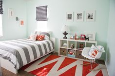 a bedroom with blue walls and striped bedding