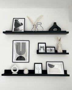 some black shelves with pictures and vases on them